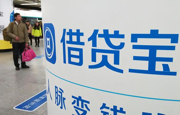 2016年1月8日，北京，一行人从借贷宝logo招牌旁经过。 图片来源：澎湃新闻