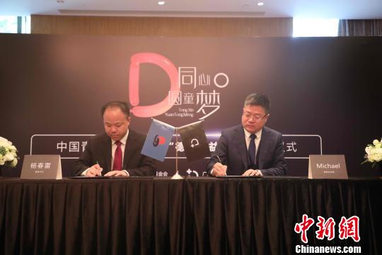 中国青基会副秘书长杨春雷(左)与德家董事Michael(右)签约成立德家公益基金。　唐贵江 摄